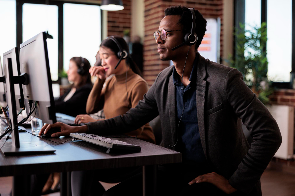 Três pessoas trabalhando como operadores em um contact center.