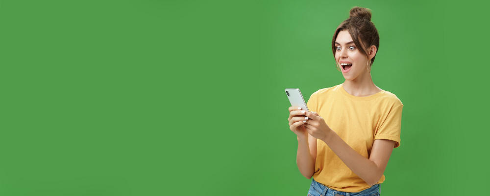 uma mulher com um smartphone na mão, com um fundo verde.